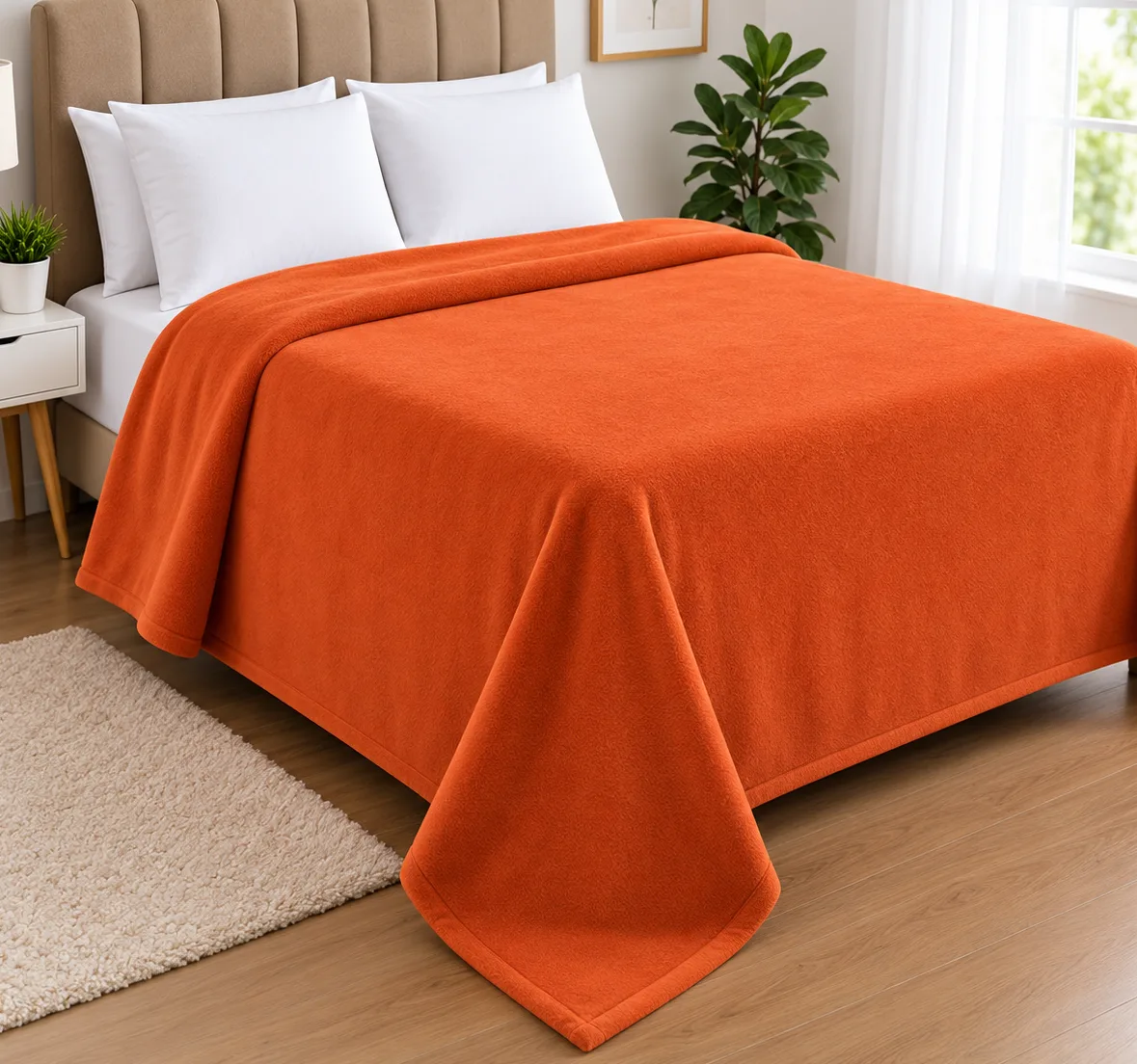 Plain polar fleece blanket in Rust on a made-up double bed