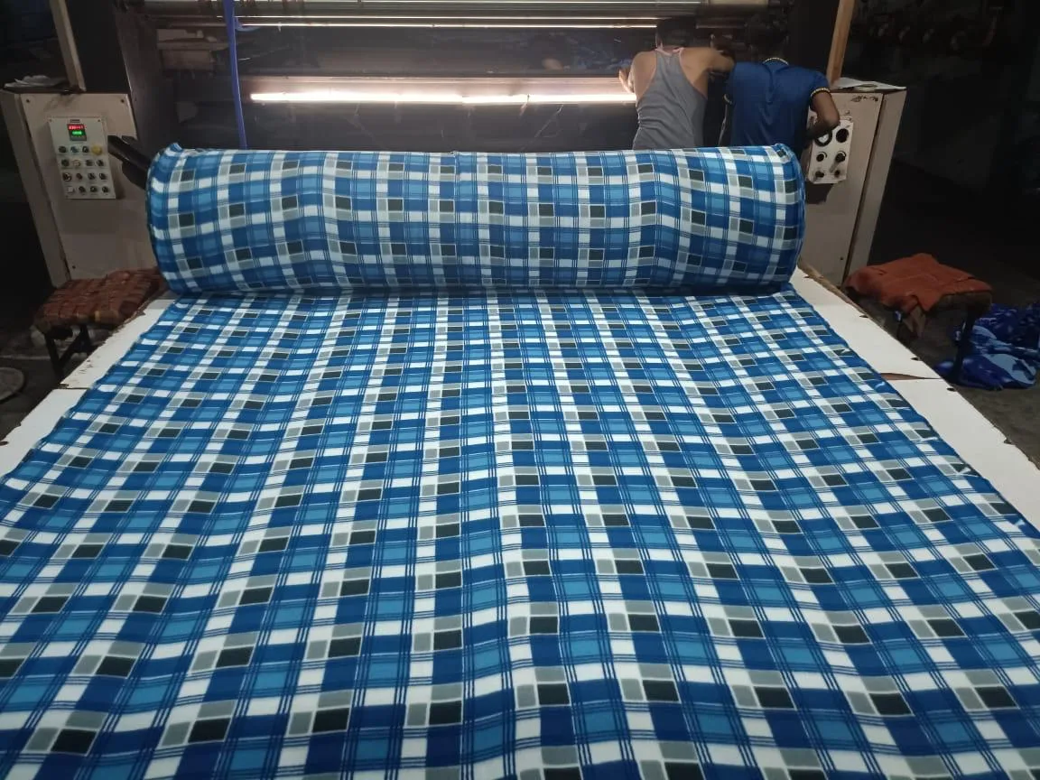 Operators inspecting printed polar fleece fabric on the machine at the Panipat unit