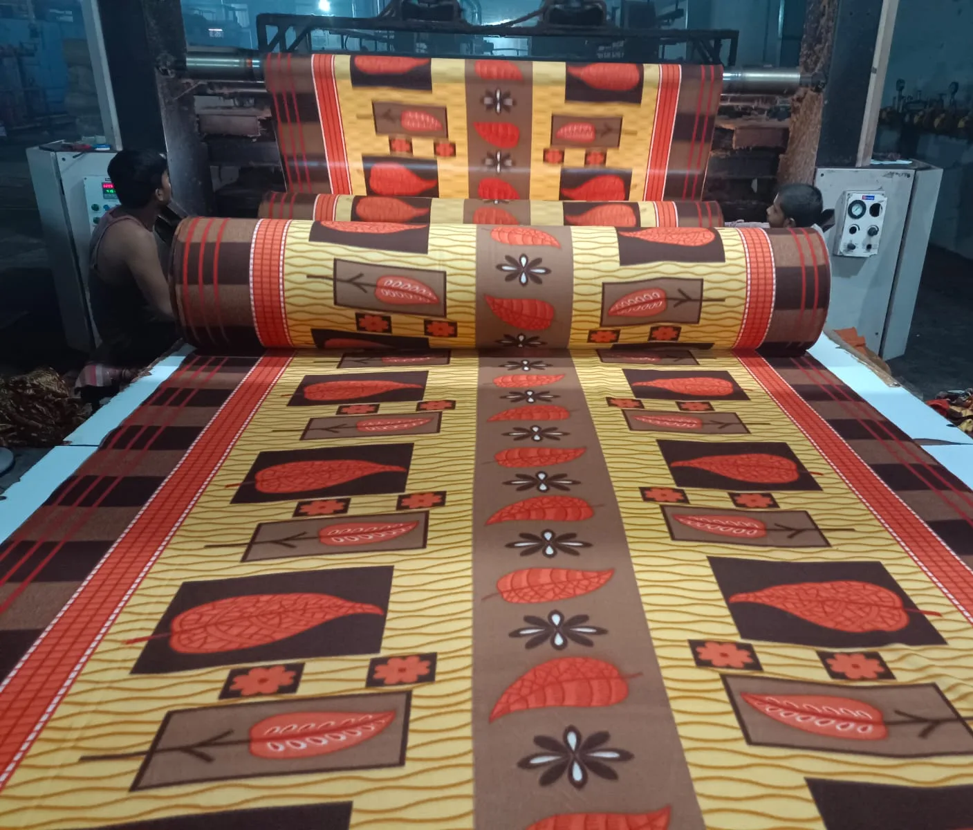 Workers operating a polar fleece printing machine at the Smiley International factory in Panipat