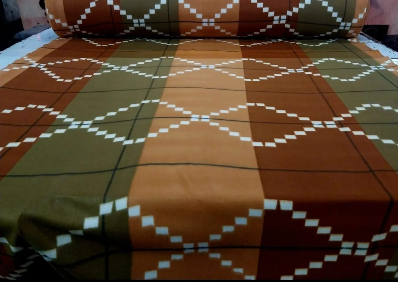 1000 GSM printed polar fleece blanket in an olive, rust and camel check with diamond motifs