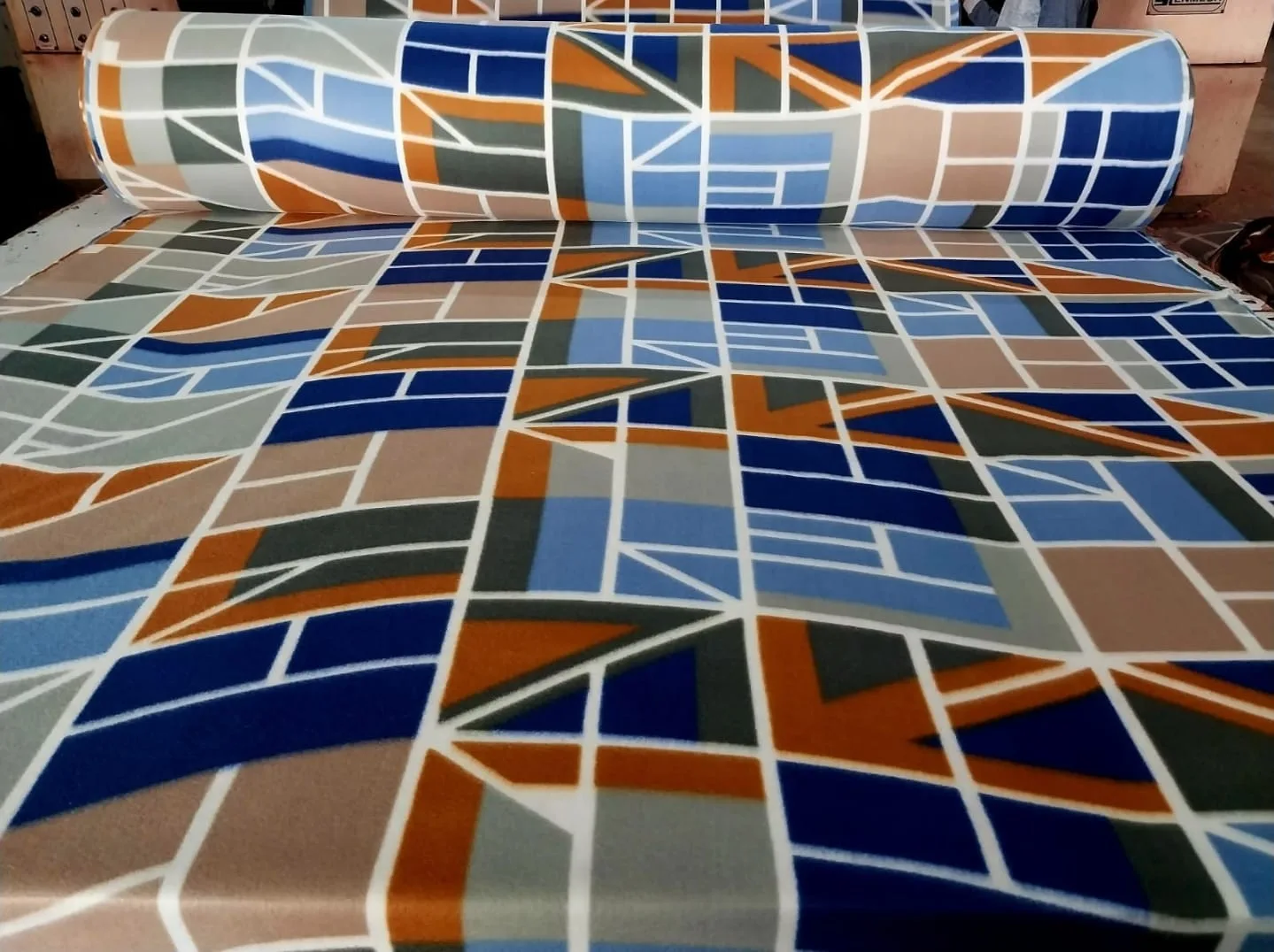 700 GSM printed polar fleece blanket fabric in a blue, orange and grey geometric mosaic print