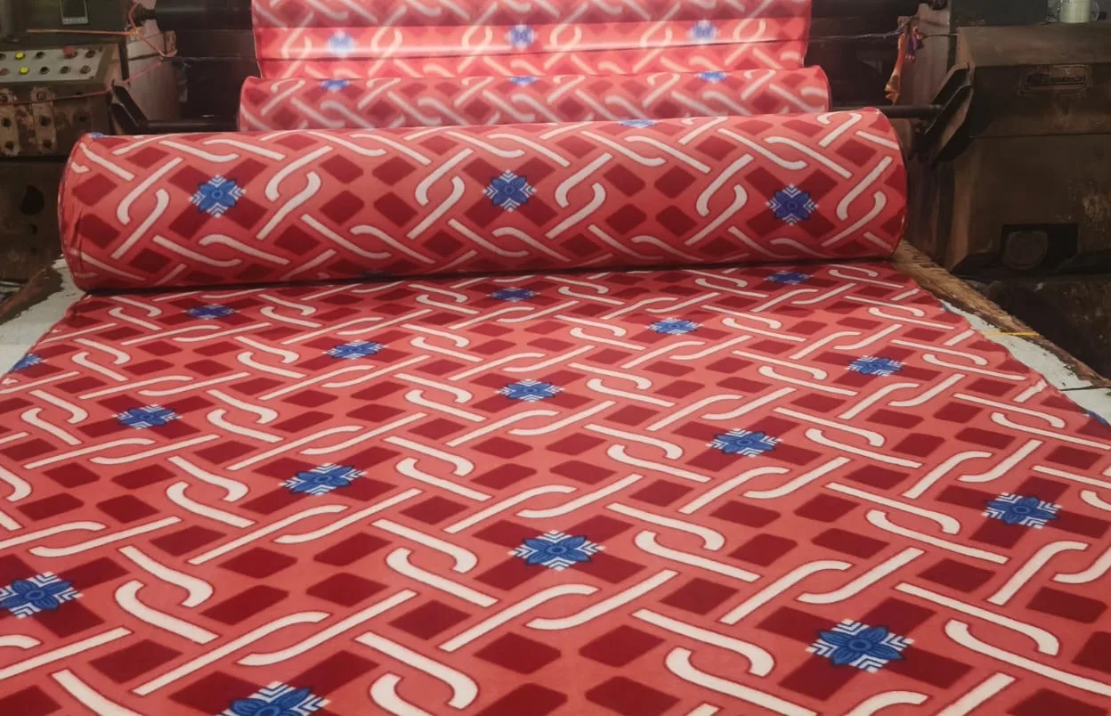 700 GSM printed polar fleece blanket fabric in a red lattice print with blue motifs